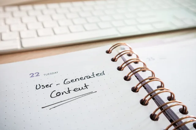 Notebook with user-generated content note and keyboard, ideal for planning and productivity. Piano editoriale social
